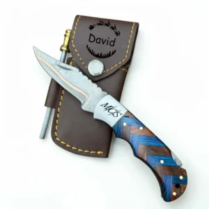 Personalized handmade Copper Damascus steel folding pocket knife with blue and walnut wood handle, custom engraving, leather sheath and fire starter.